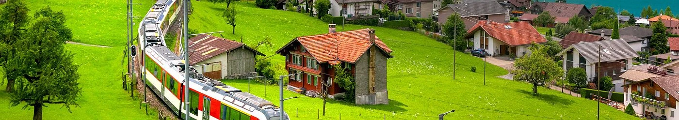Un tren și case tradiționale în Alpii Elvețieni