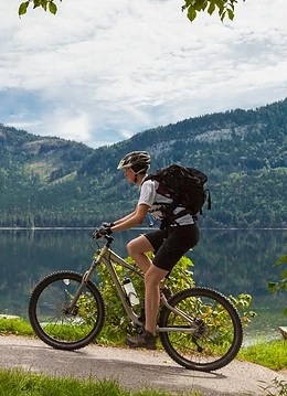 Un biciclist plimbându-se pe lângă un lac