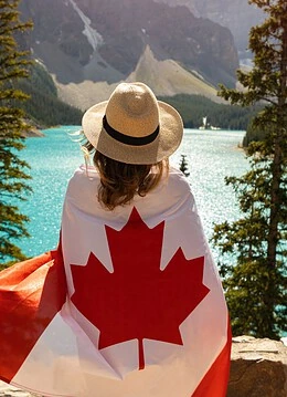 O femeie purtând steagul canadei într-un parc