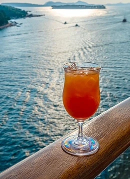 Un cocktail exotic așezat în fața unui peisaj maritim