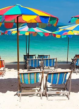 Șezlonguri și umbrele pe o plajă cu nisip alb