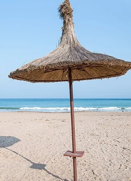 O umbrelă de plajă pe o plajă
