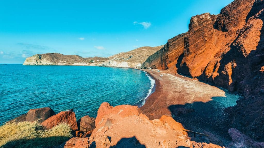 Zona de coastă a plaje Red Beach, înconjurată de stânci înalte.