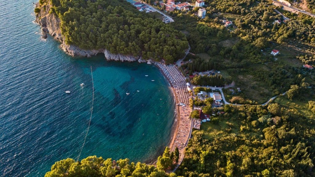 Zona de coastă a plajei Lucice înconjurată de faună verde.