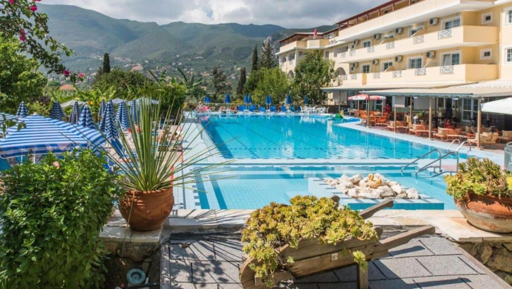 O piscină exterioară dublă lângă aranjamentele decorative ale unui hotel.