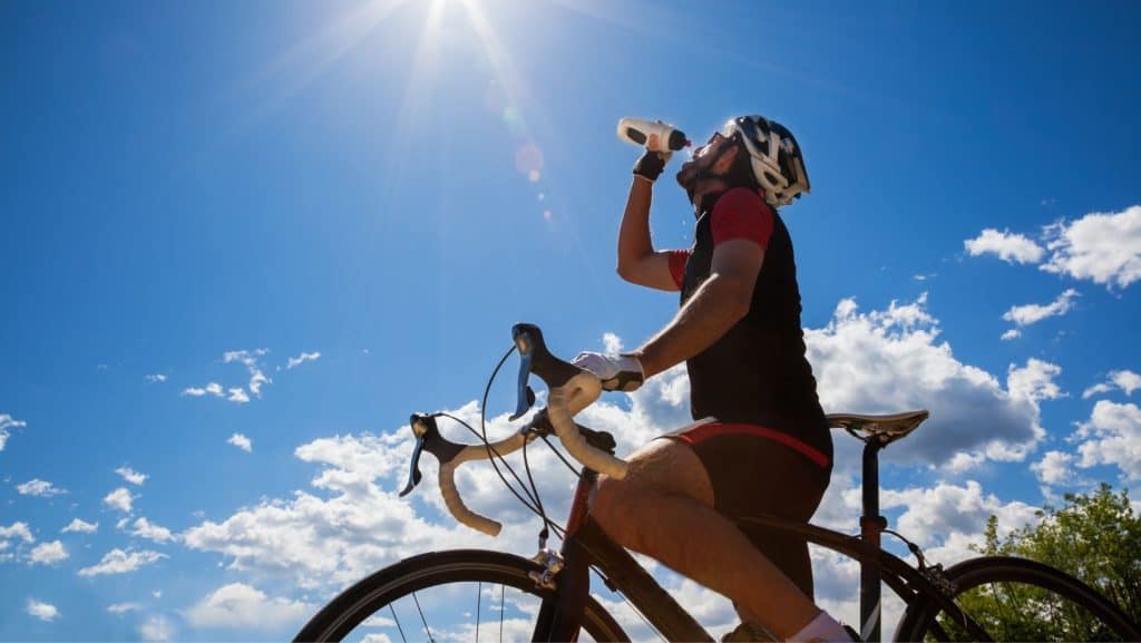 Un biciclist care se hidratează