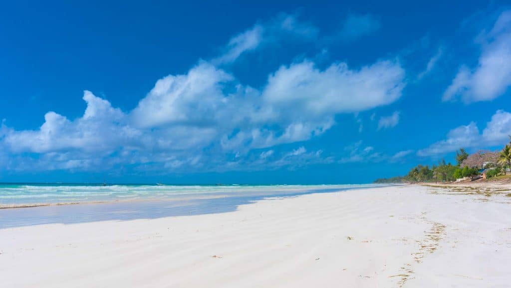 Zonă de coastă cu nisip alb și apă turcoaz pe plaja Diani Beach din Kenya