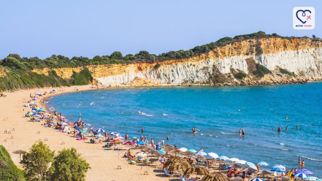 O plajă vastă cu turiști și șezlonguri într-o zonă de coastă